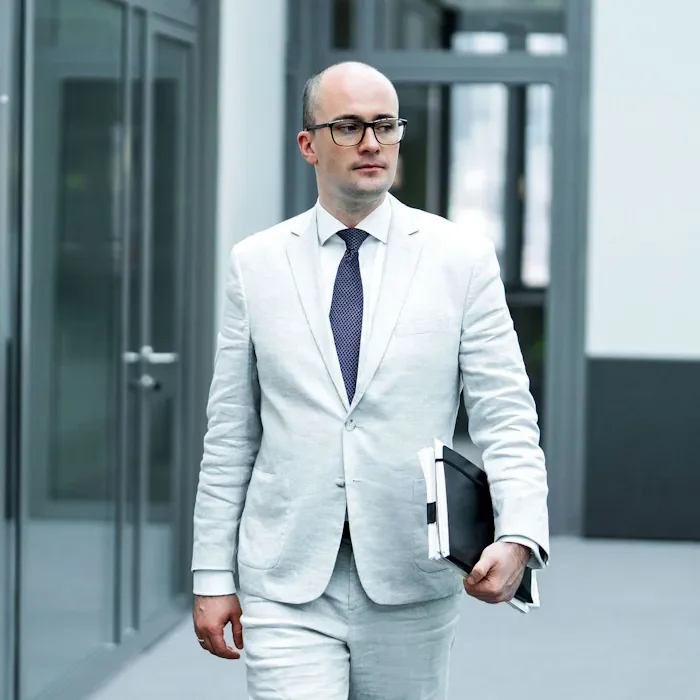 Rechtsanwalt Raphael Griemert läuft durch ein modernes Bürogebäude.